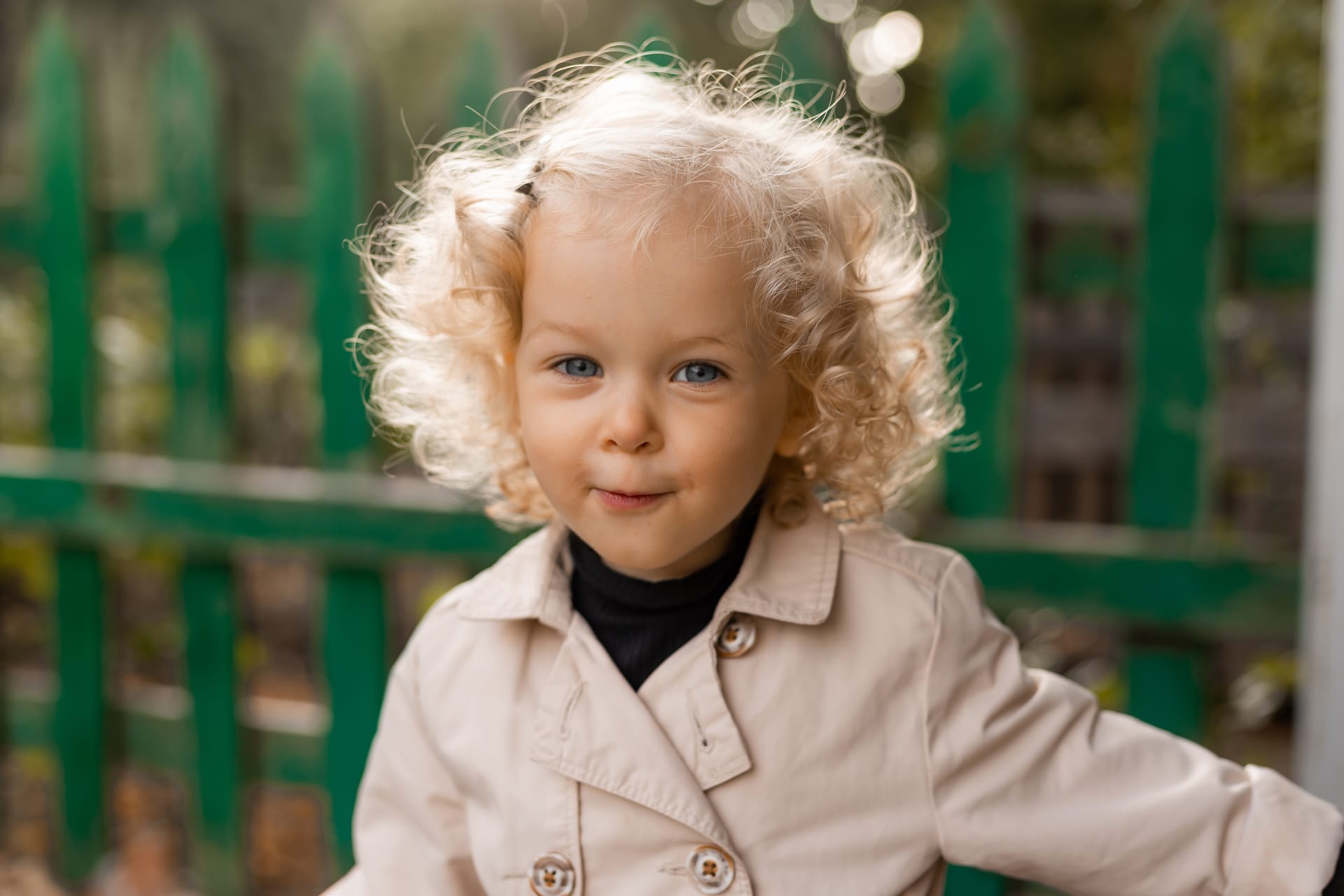 Curly blonde girl with blue eyes white linen raincoat image