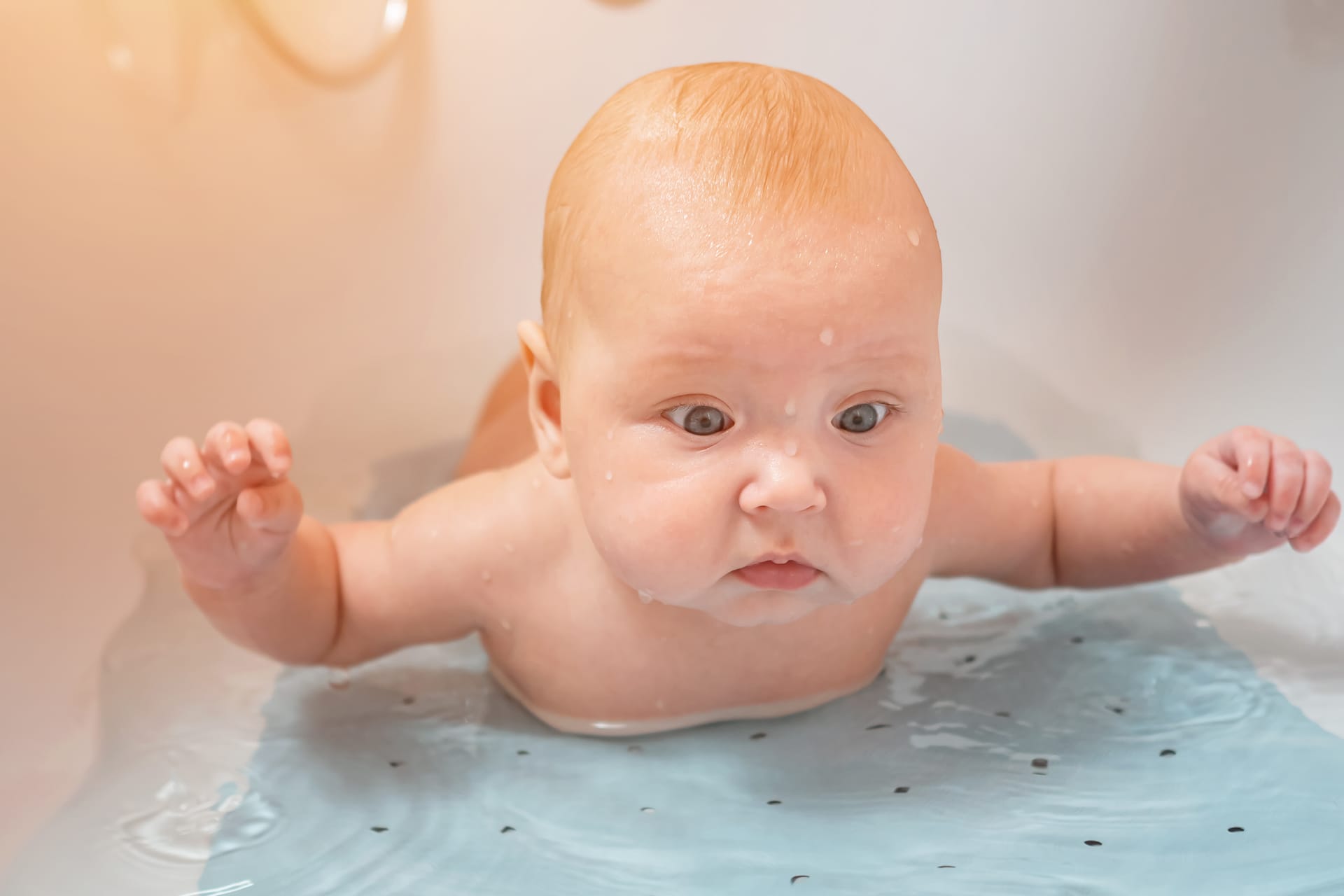 Girl lies bathtub with water child looks camera with wonderment