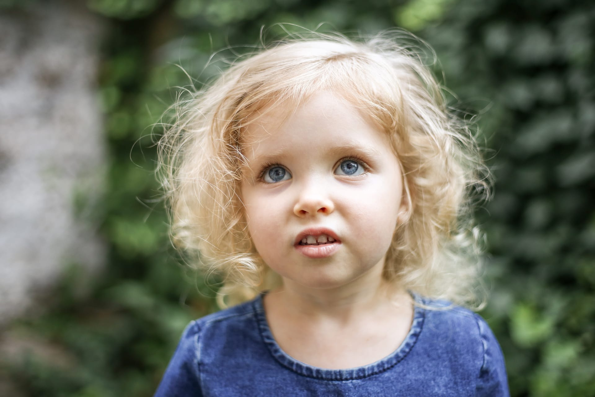 Little beautiful european girl with curly blonde hair blue eyes