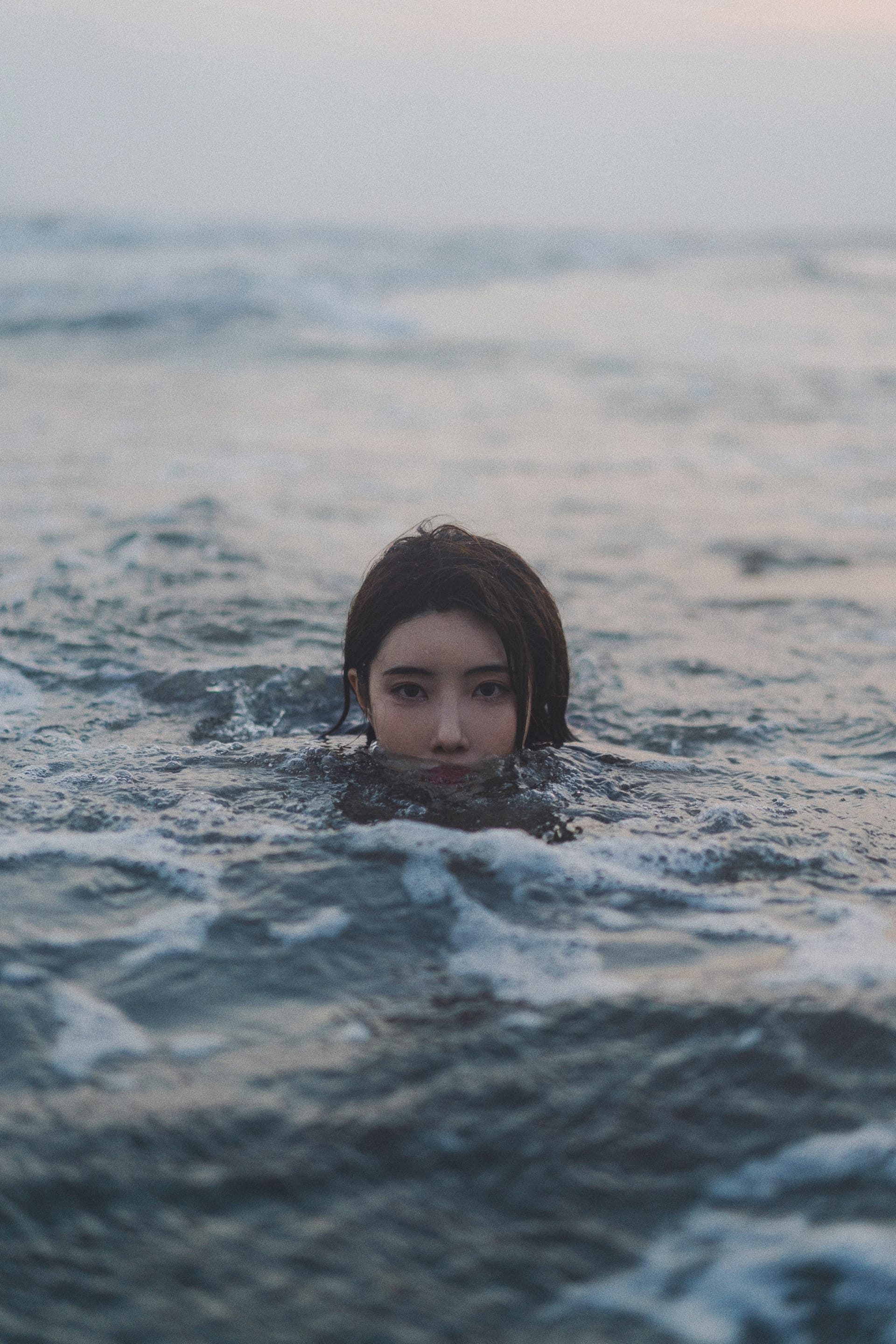 Young south korean brunette woman swimming sea morning