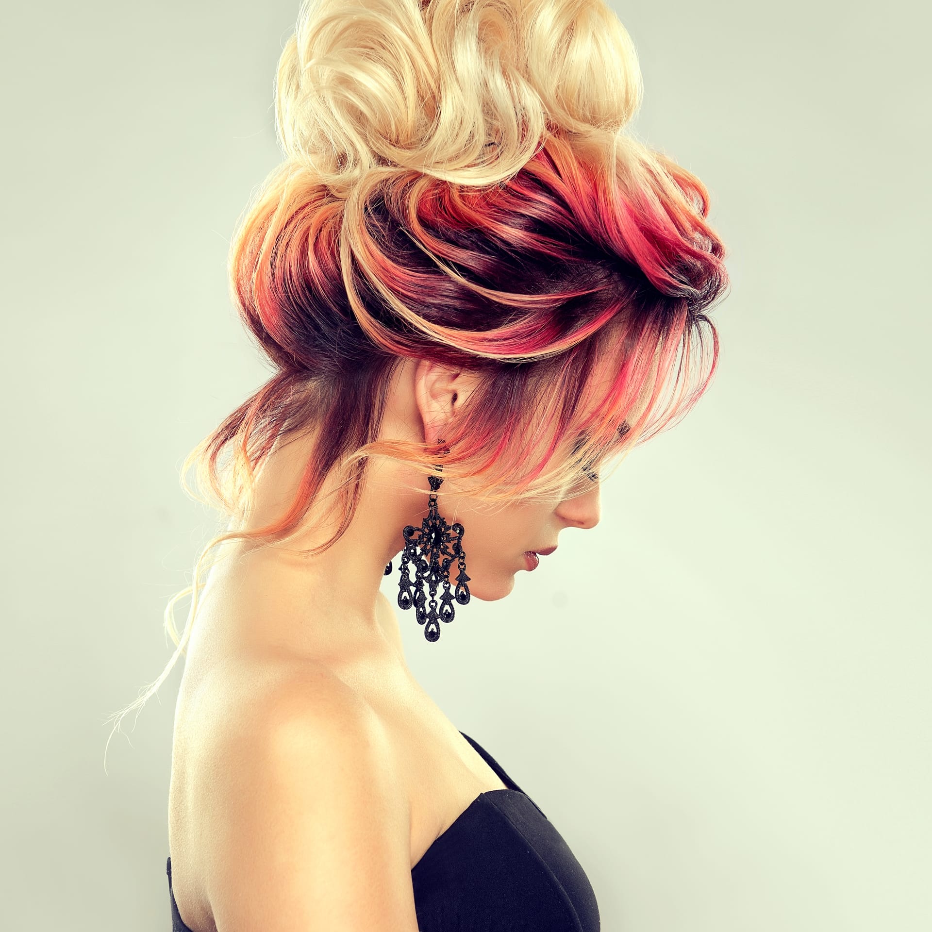 Hair gathered elegant evening hairstyle with big blonde bun hairdressing art coloration hair