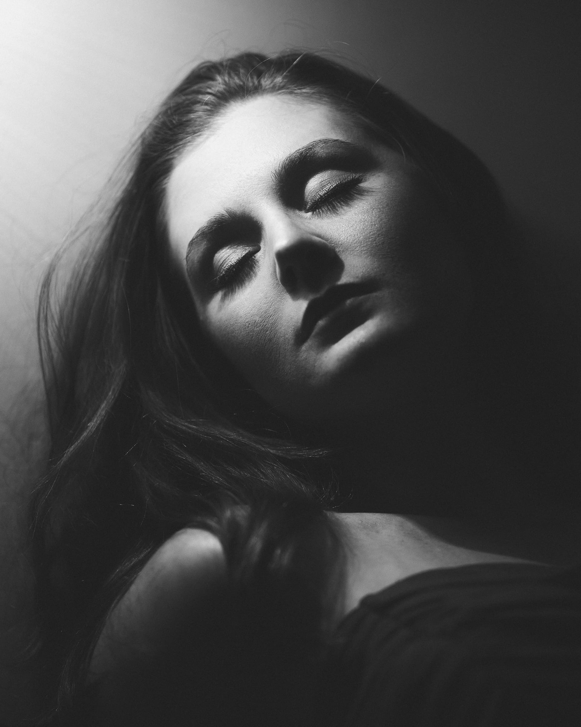 Grayscale portrait melancholic brunette woman sleeping lamplight