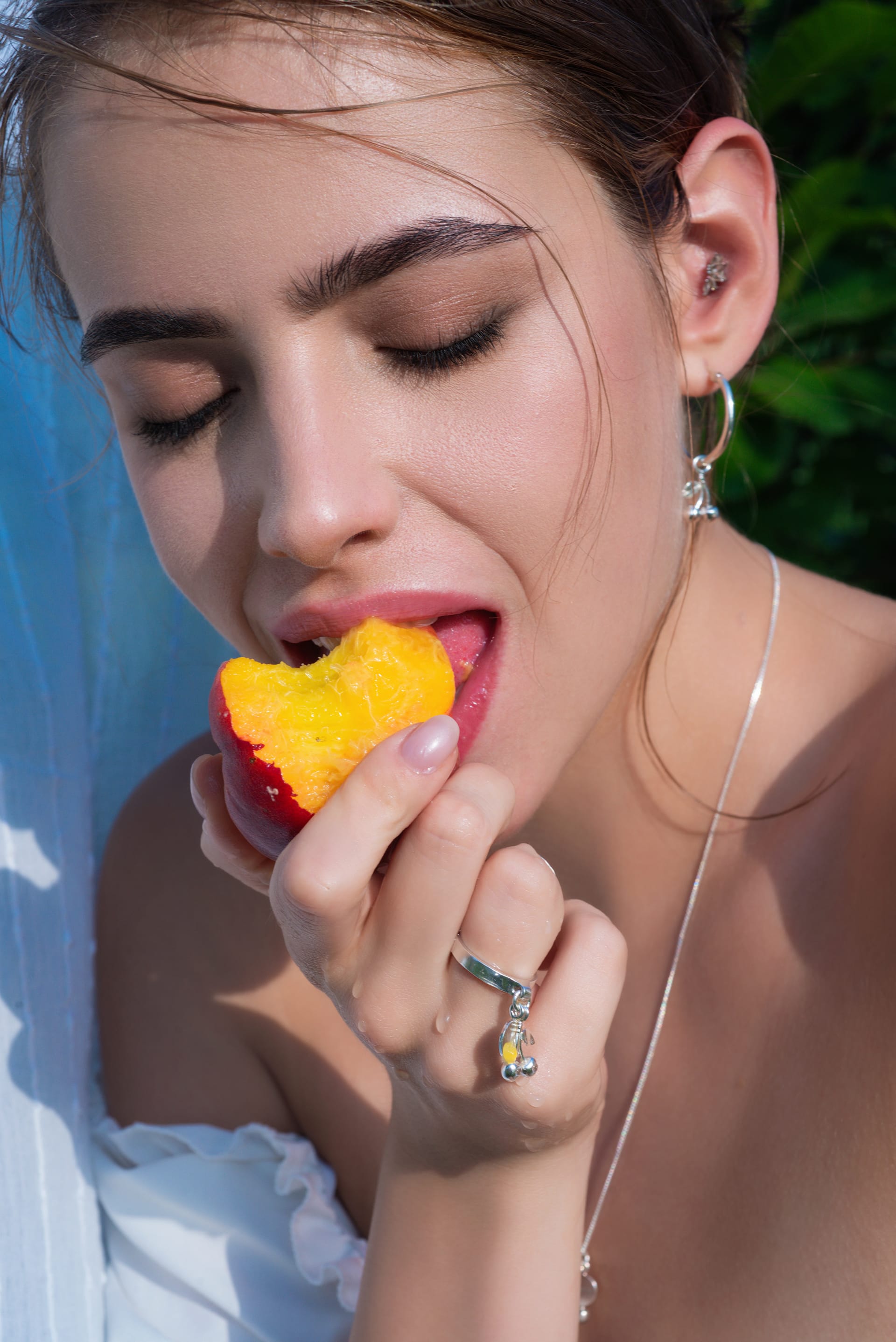 Stylish sensual woman posing summer greenery outdoor woman eat peach close up count