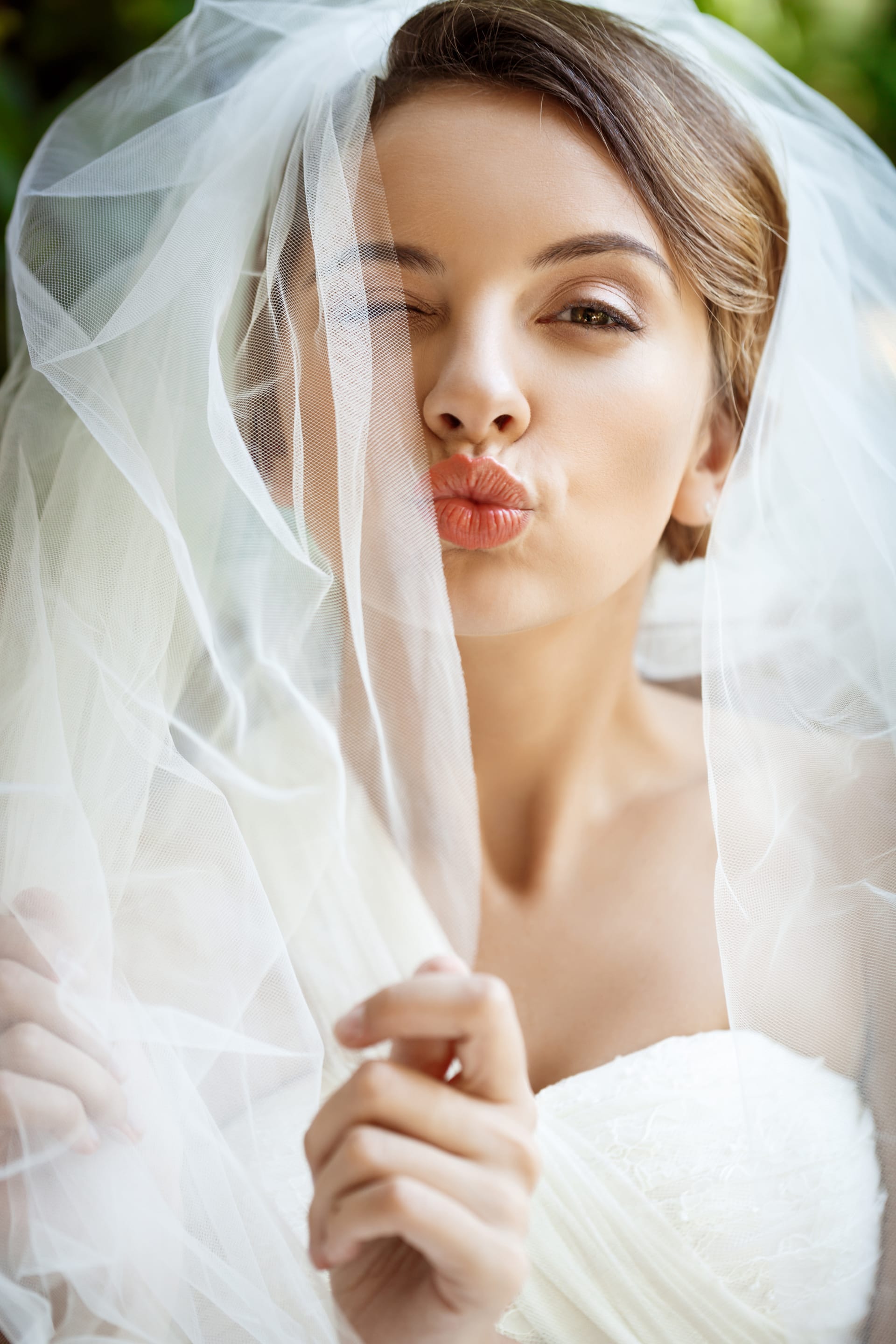 Beautiful bride wedding dress veil winking sending kiss