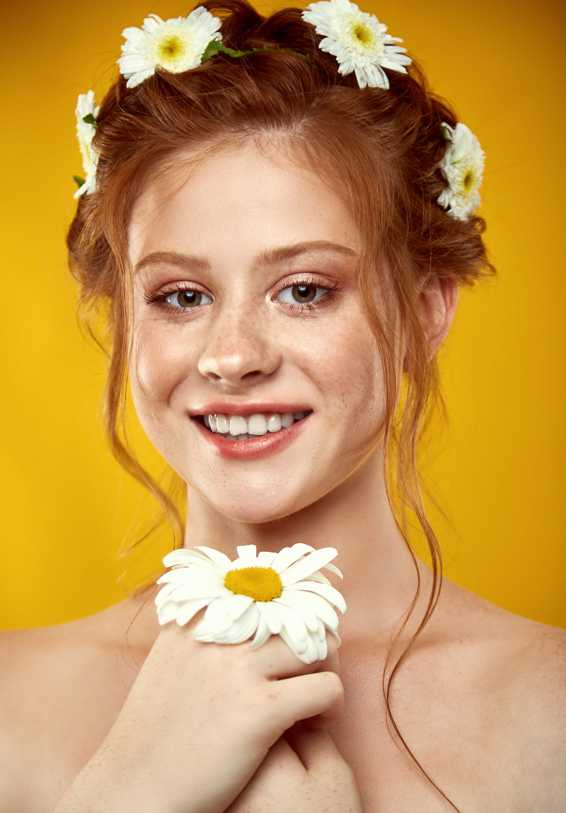 Beautiful positive redheaded girl with chamomile crown her head image