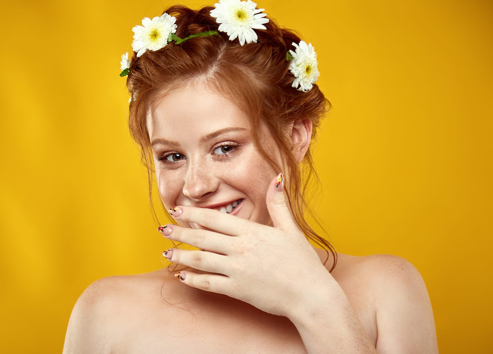 Beautiful positive redheaded girl with chamomile crown her head
