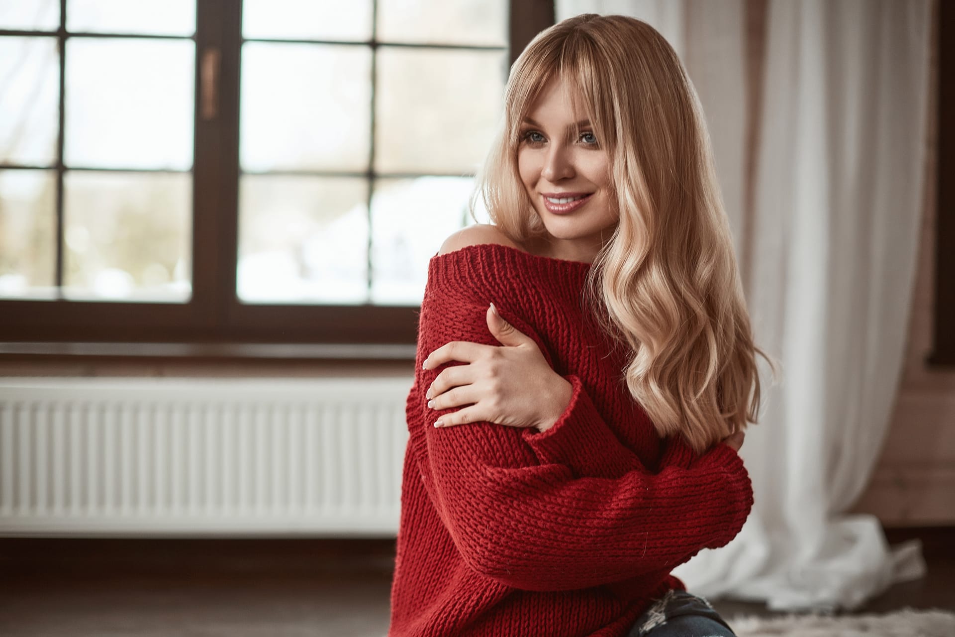 Georgeous elegant blonde woman sitting red sweater