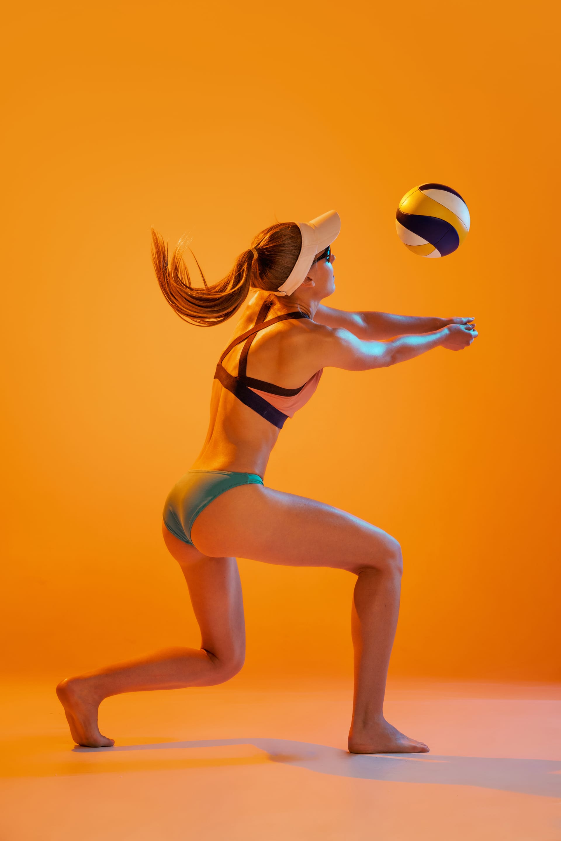 Girl playing training volleyball isolated yellow studio background neon light