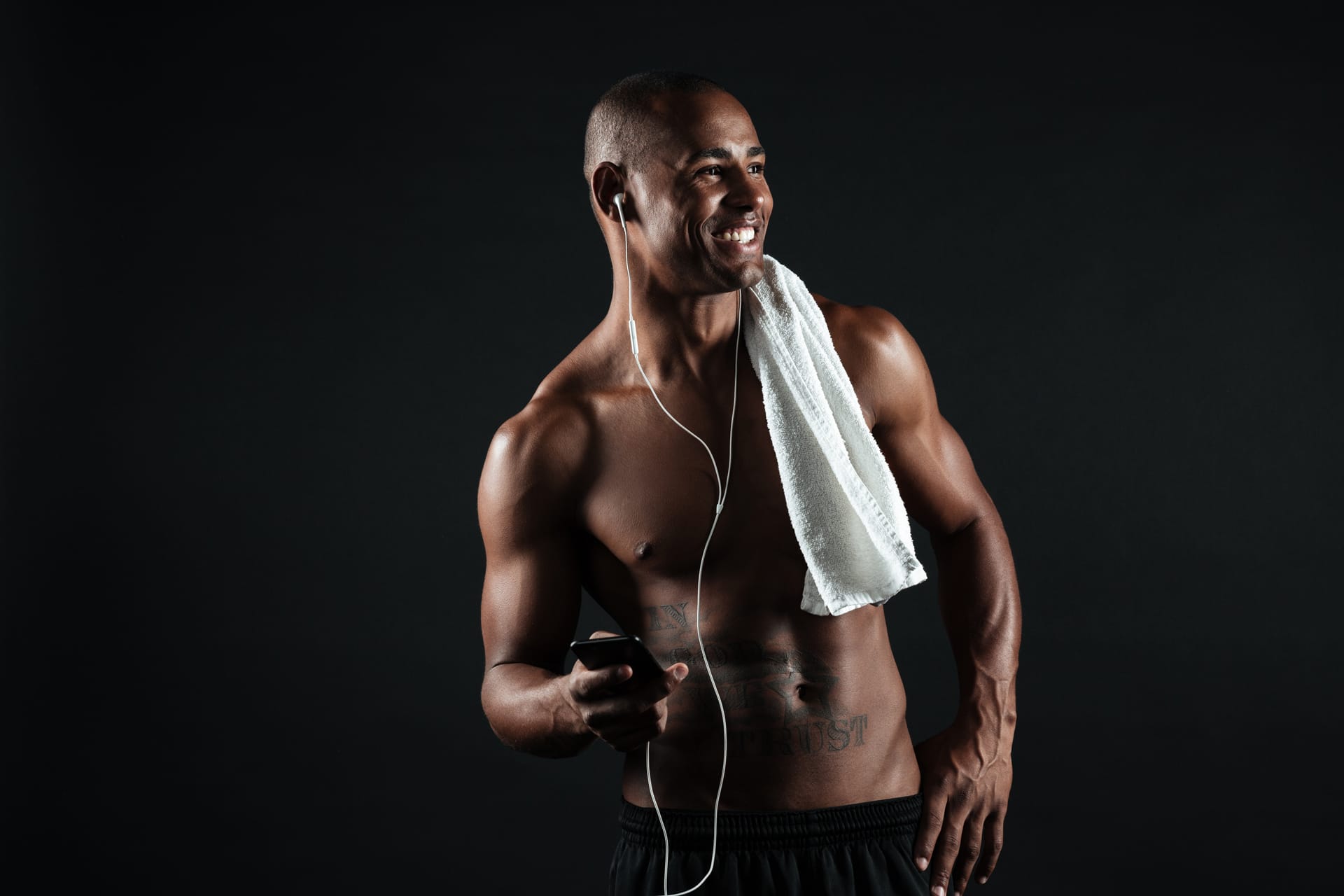 Sports afro american man with towel holding phone listen music