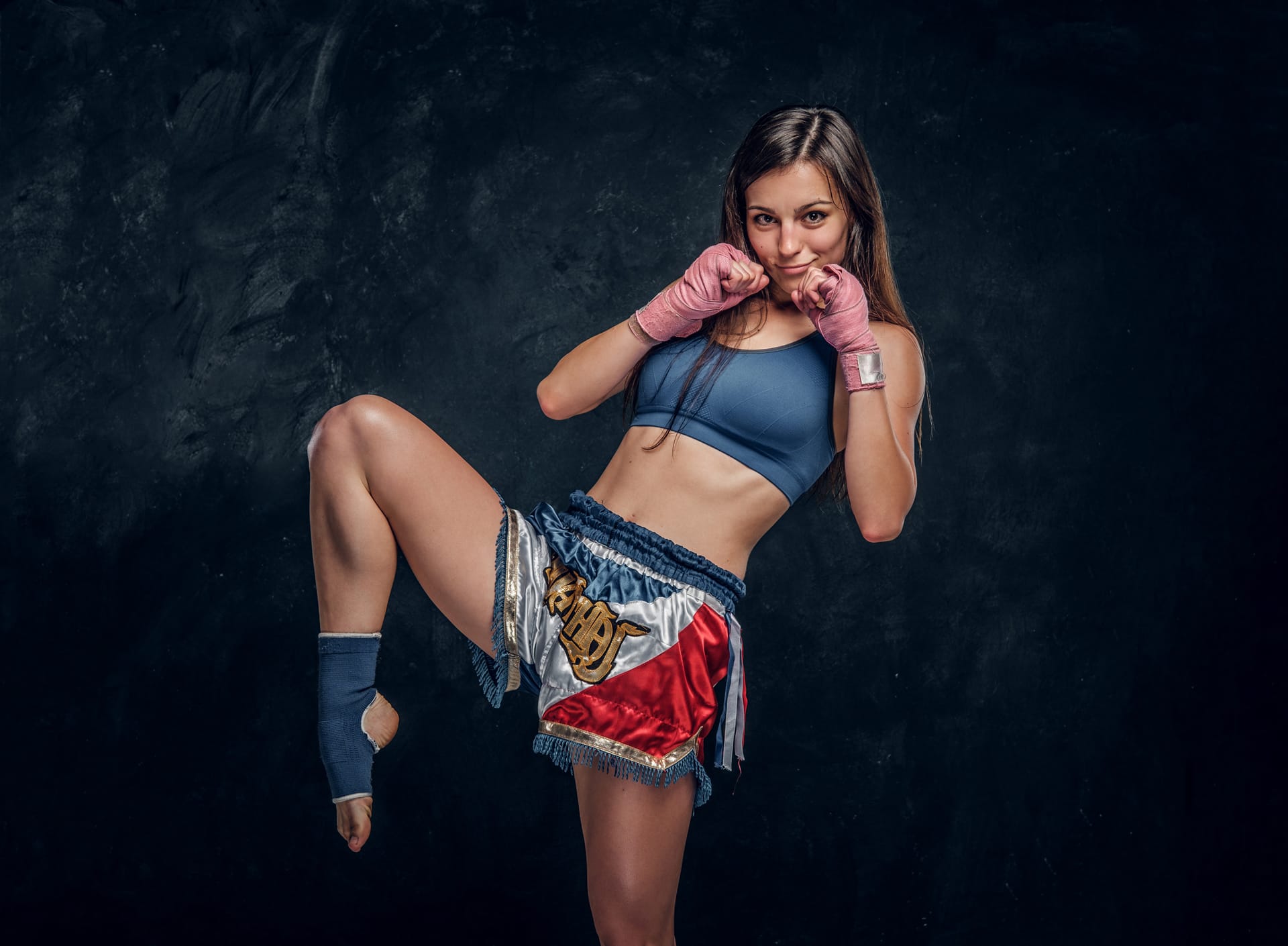 Woman is demonstrating her kick boxer pose while posing photographer
