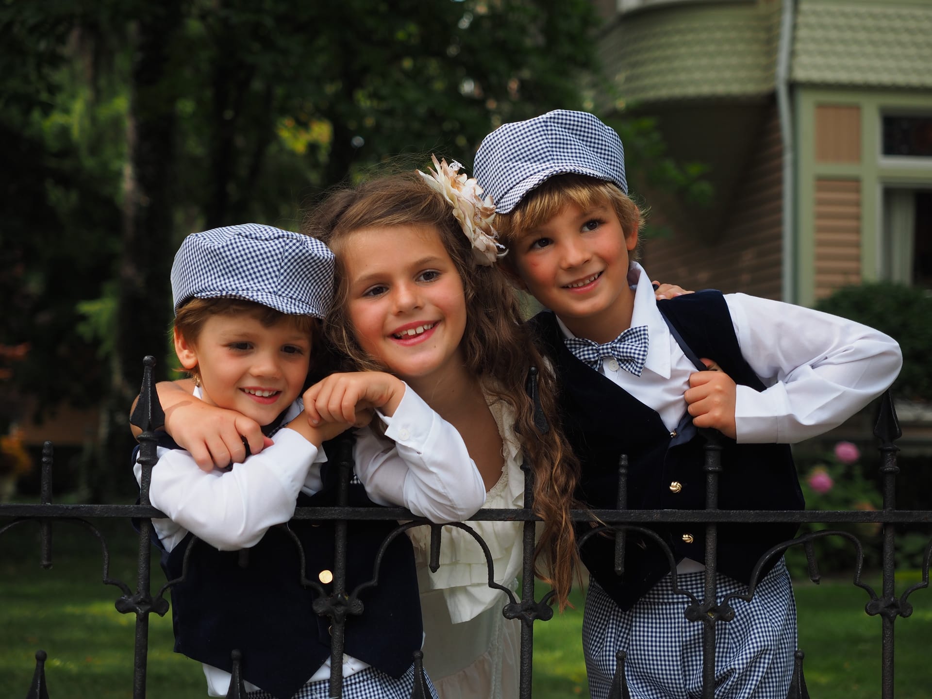Shot cute little girl two boys identical costumes standing fence