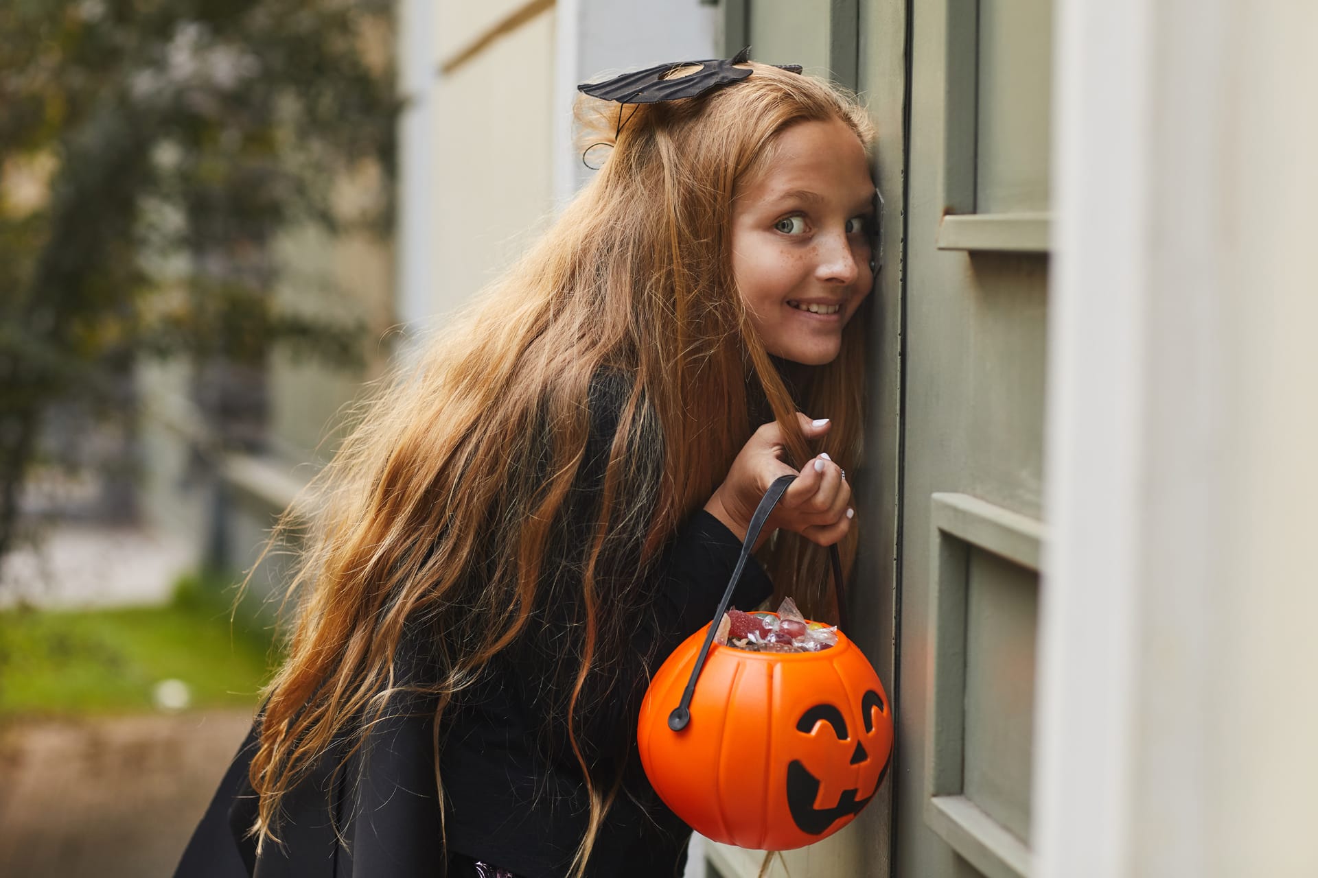 Girl listening door while playing hide seek trick treating halloween