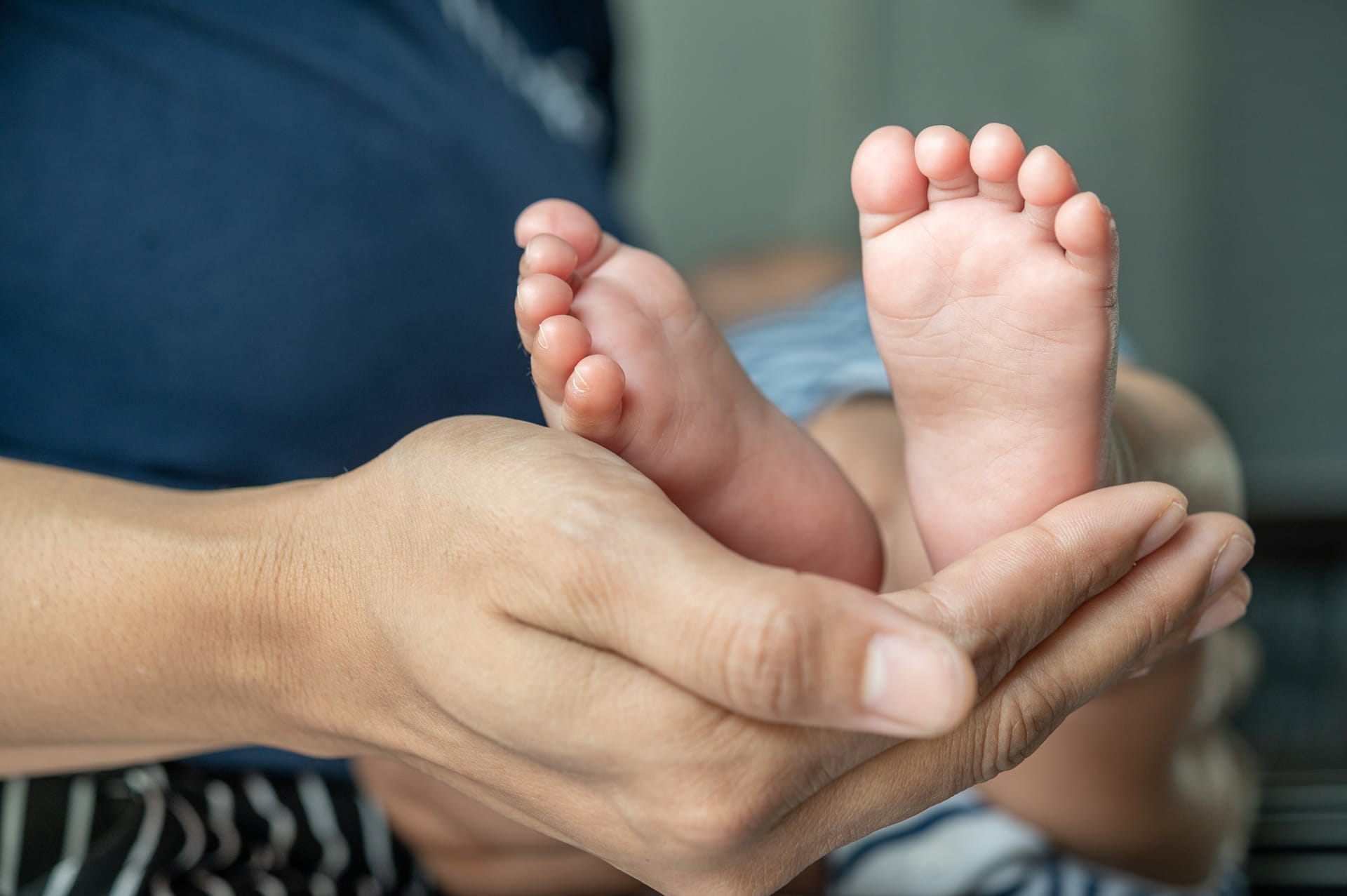 Mothers hand graced feet newborn image