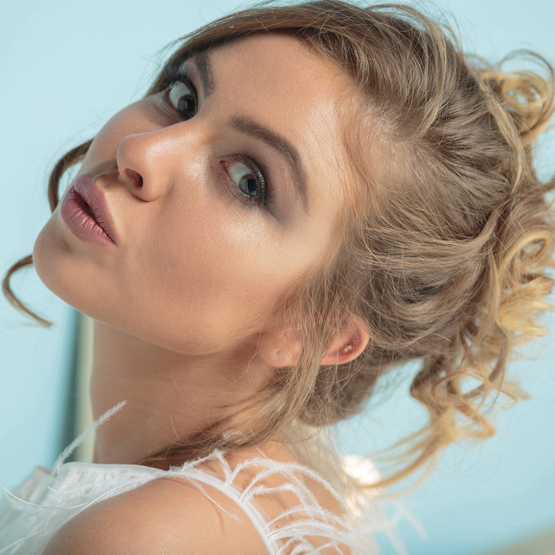 Beautiful blonde model looking camera blue background closeup photo high quality photo