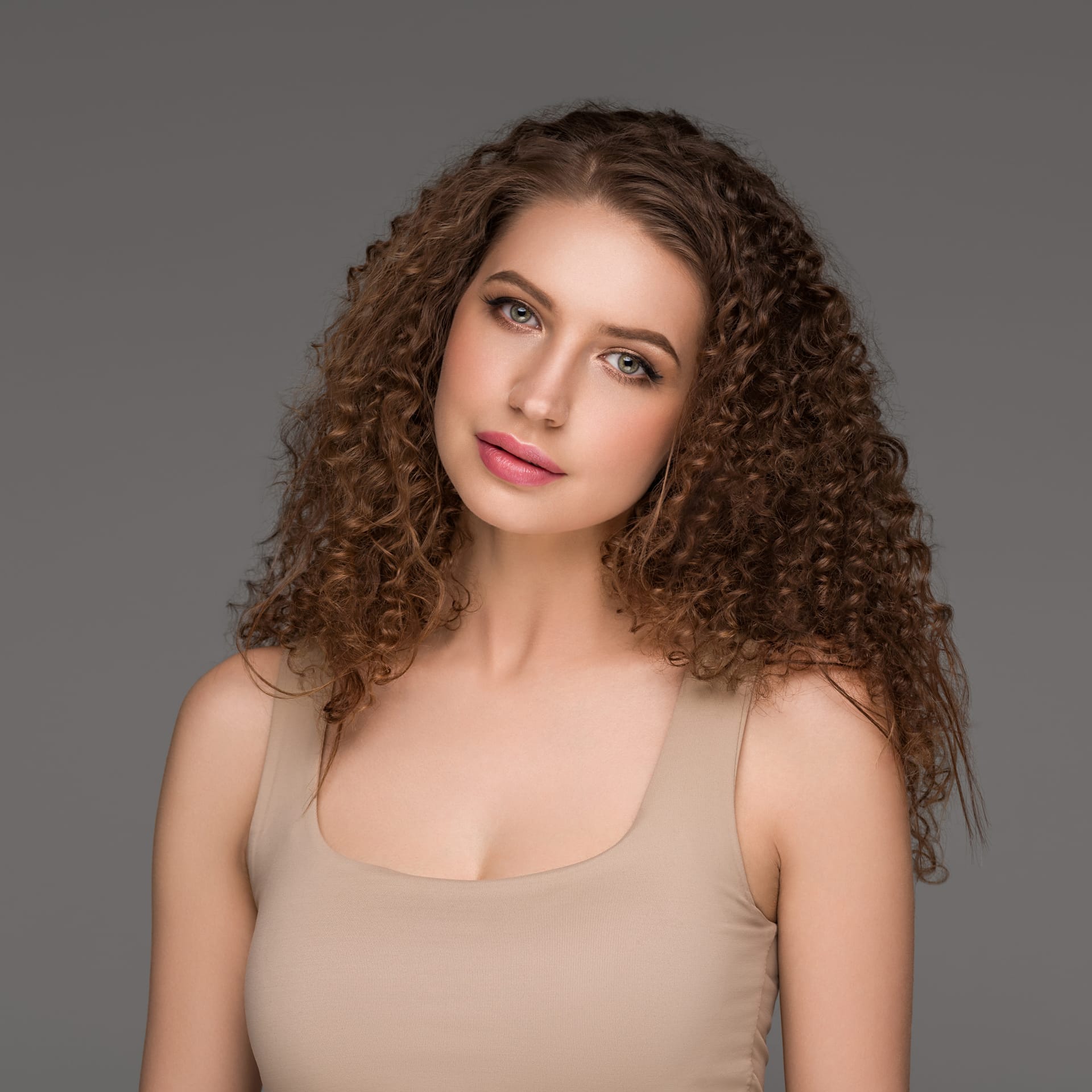 Curly long brunette hair woman beauty portrait female glamour face color backgound gray