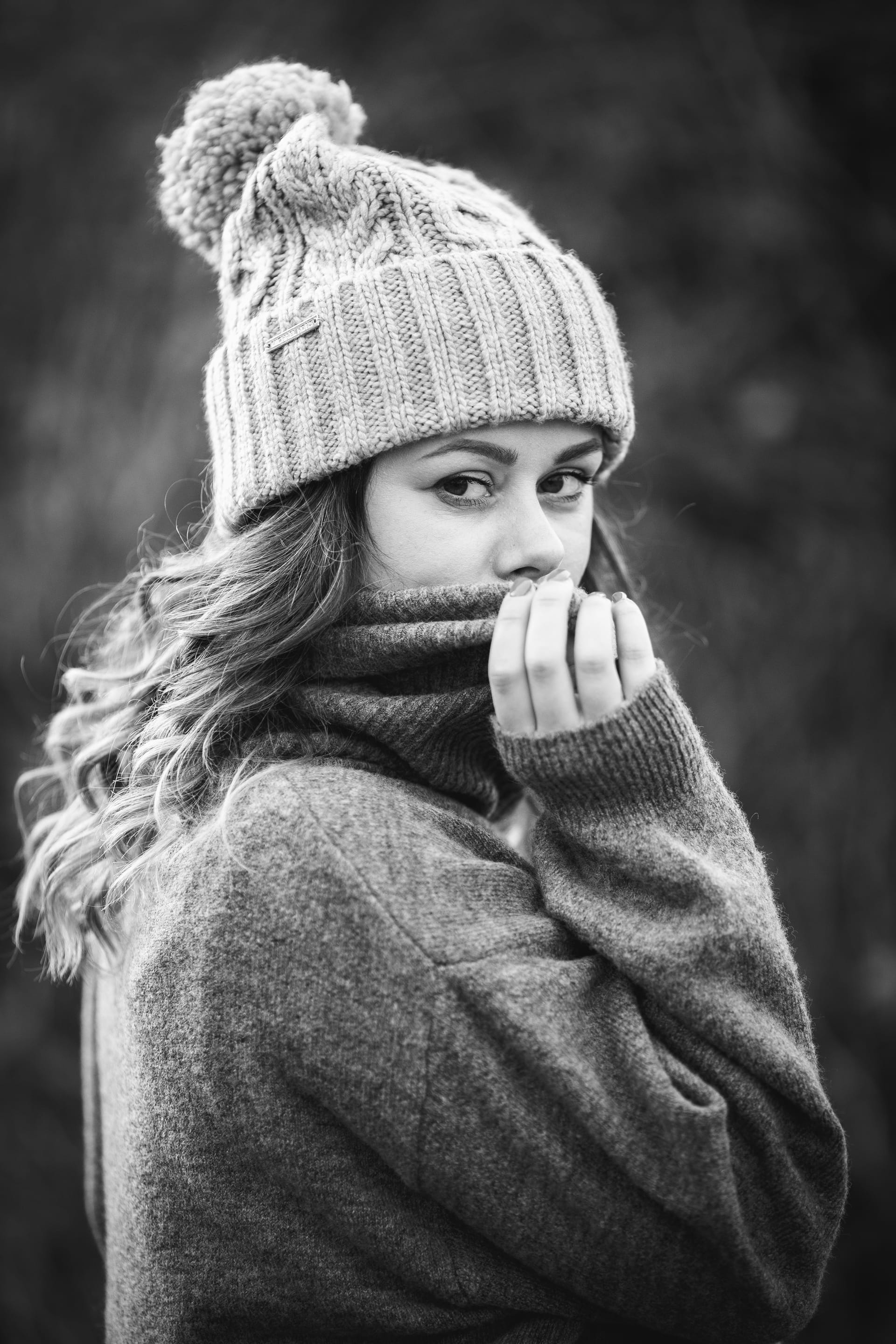 Grayscale shot young caucasian woman wearing gray sweater winter hat winter concept