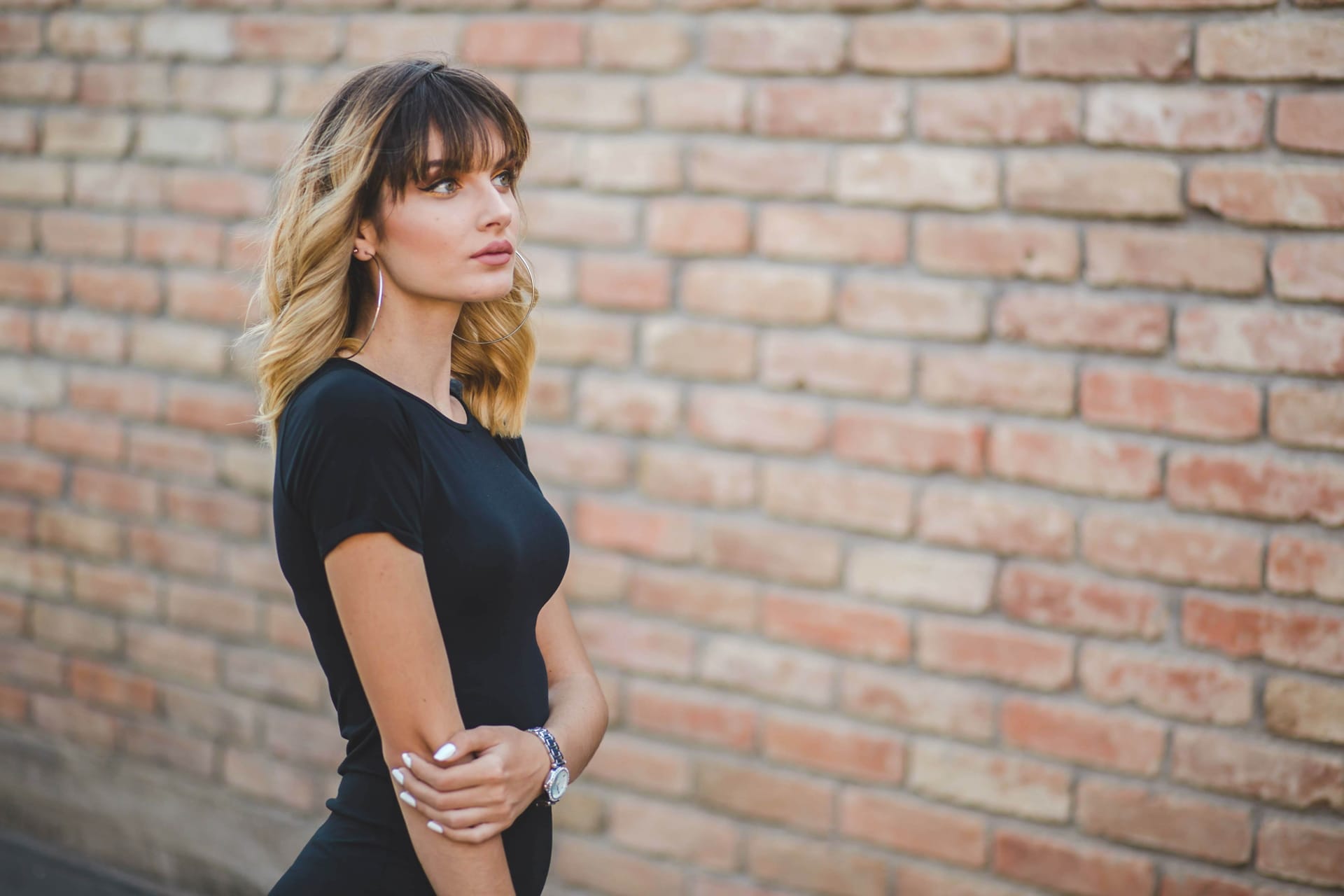 Shallow focus young bosnian woman with brick wall background