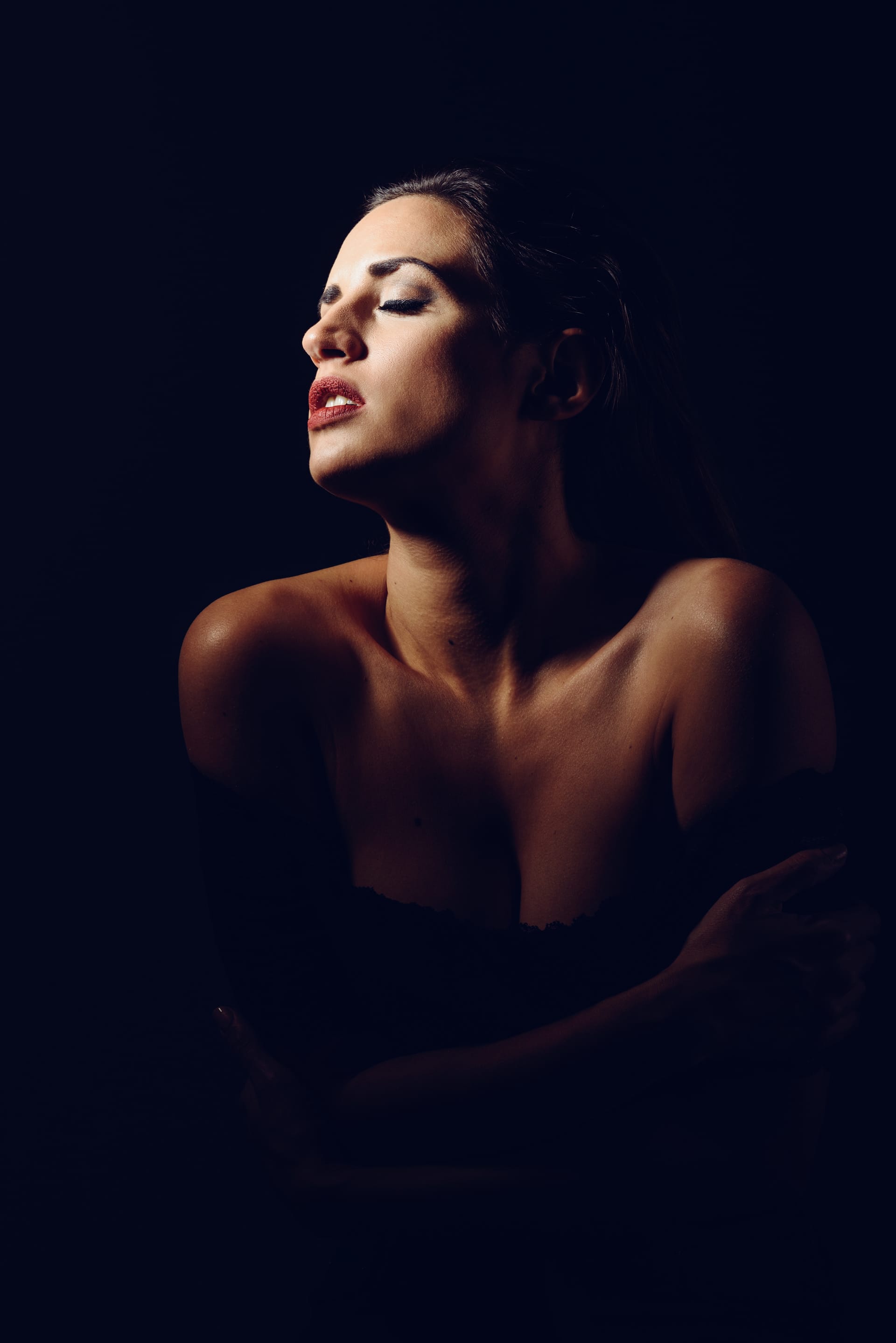 Young brunette woman black lingerie chiaroscuro lighting