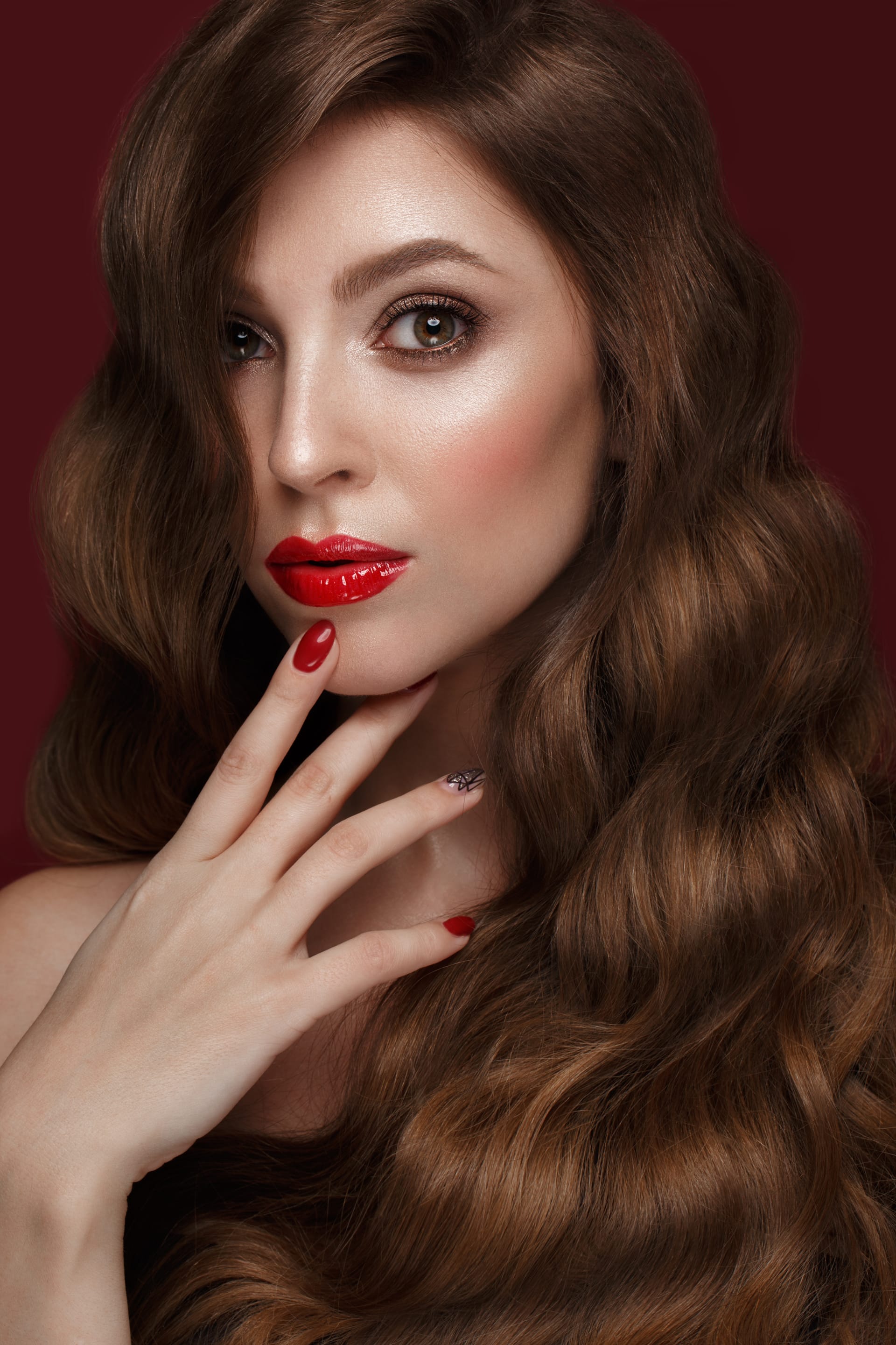 Woman with classic make up curls hair red nails