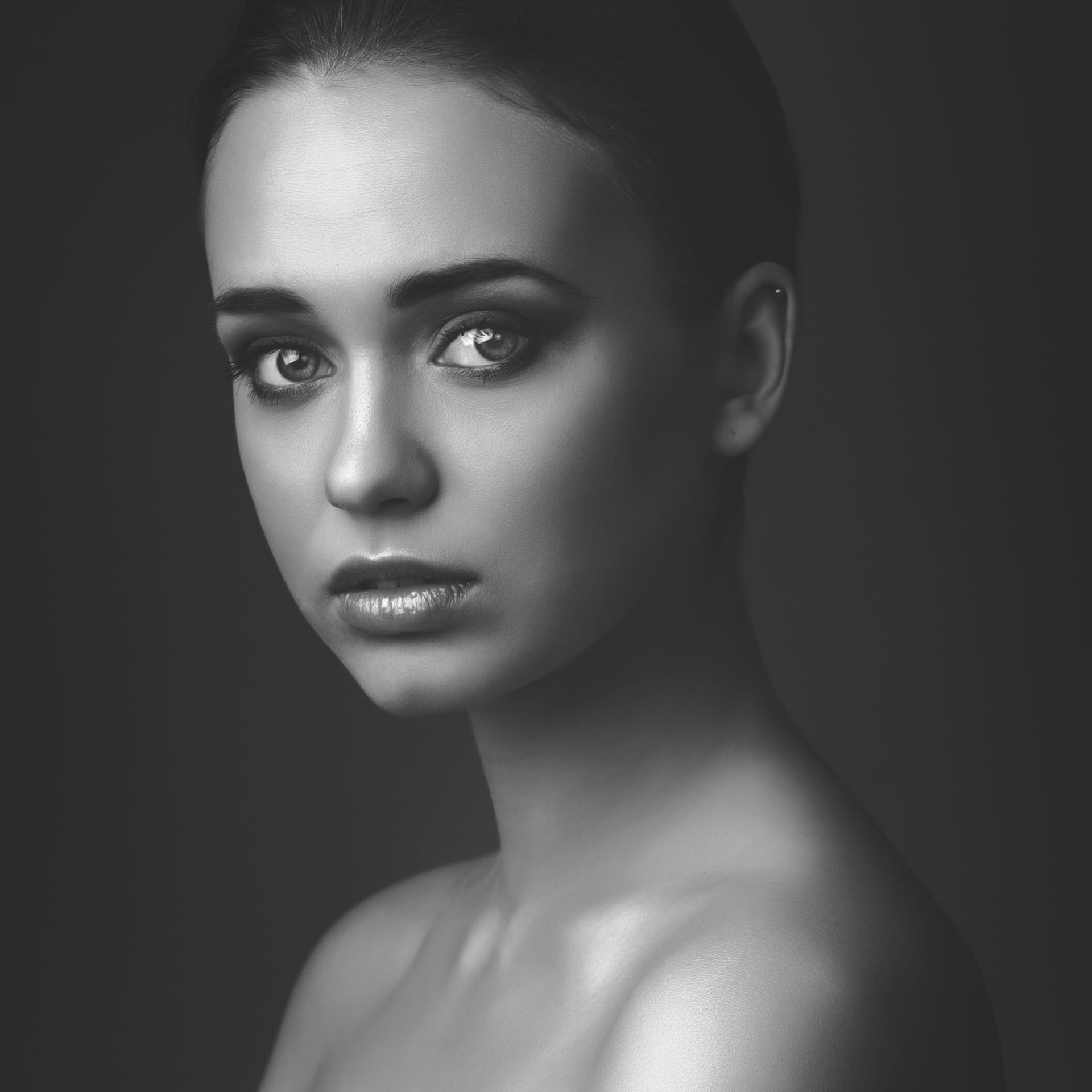 Studio portrait young beautiful girl dark background black white image