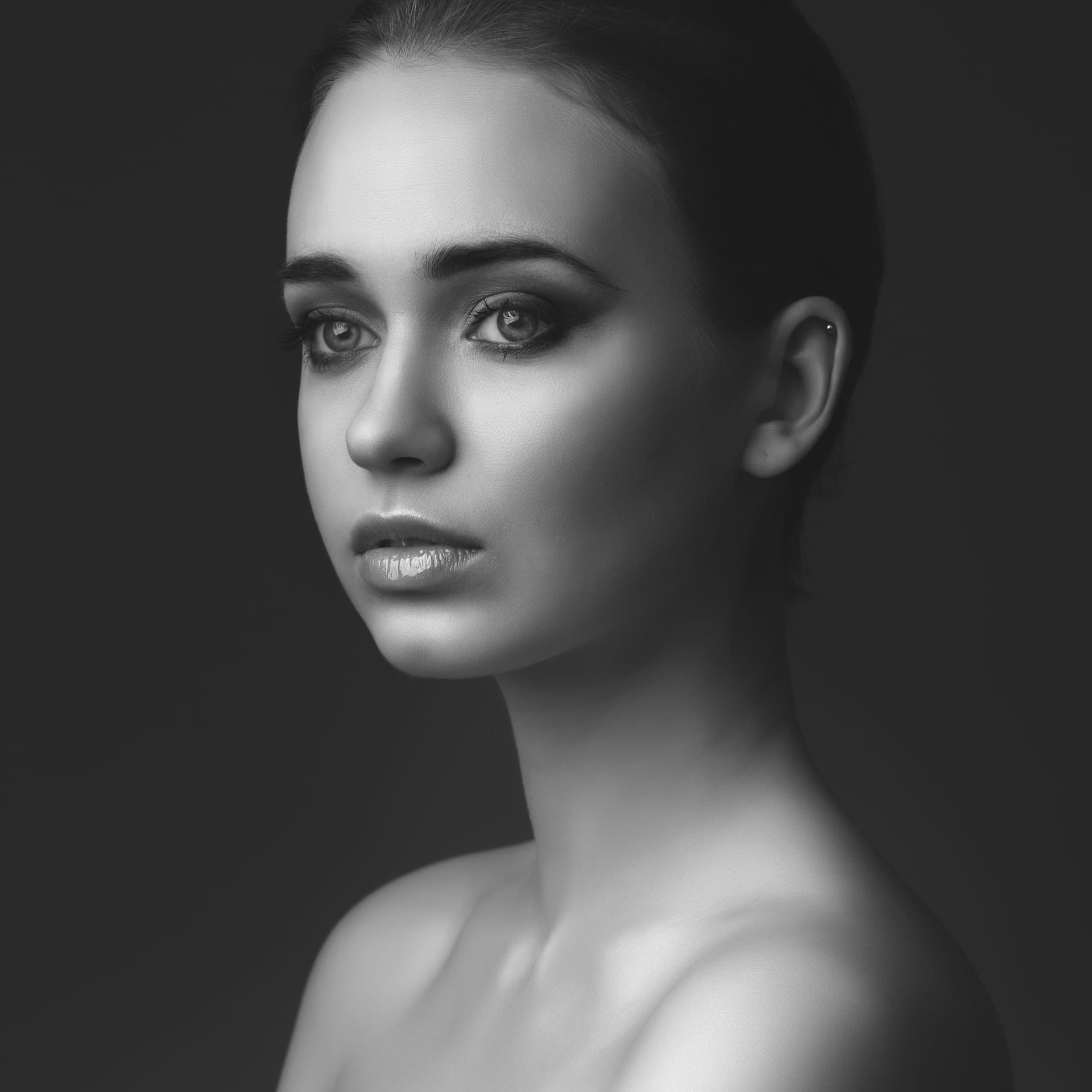 Studio portrait young beautiful girl dark background black white