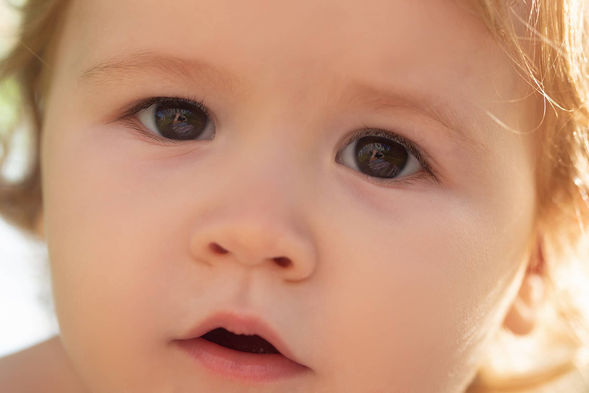Portrait small blond baby boy cropped face funny kids face