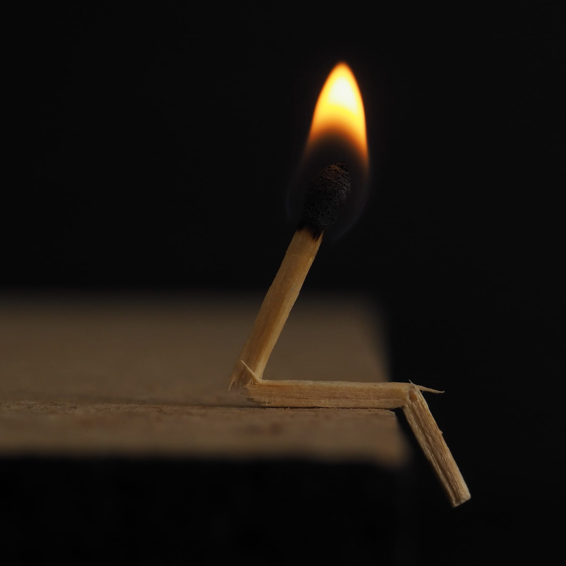 A lighted match on a wooden table