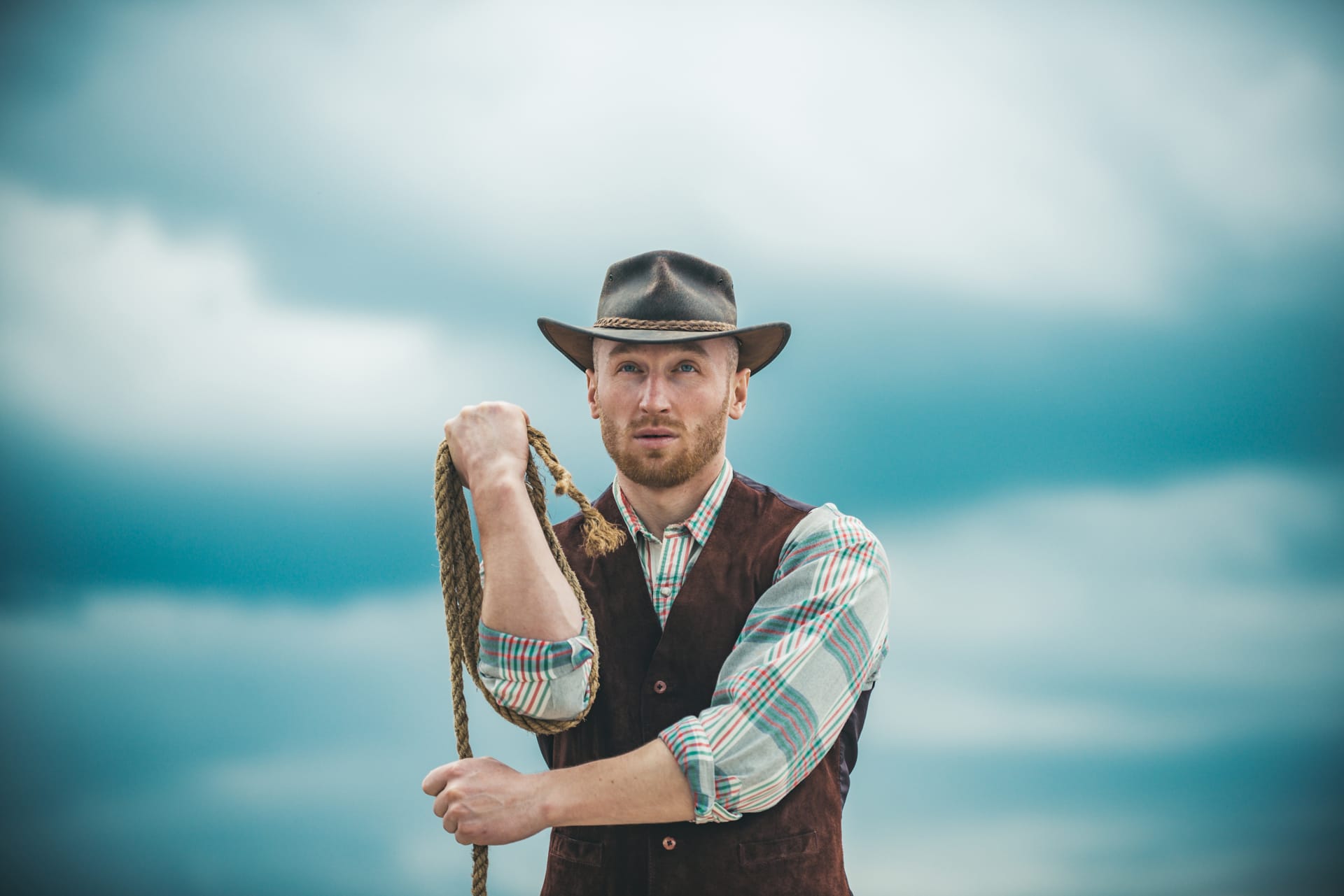 Western man with cowboy hat cowboy with lasso rope sky background