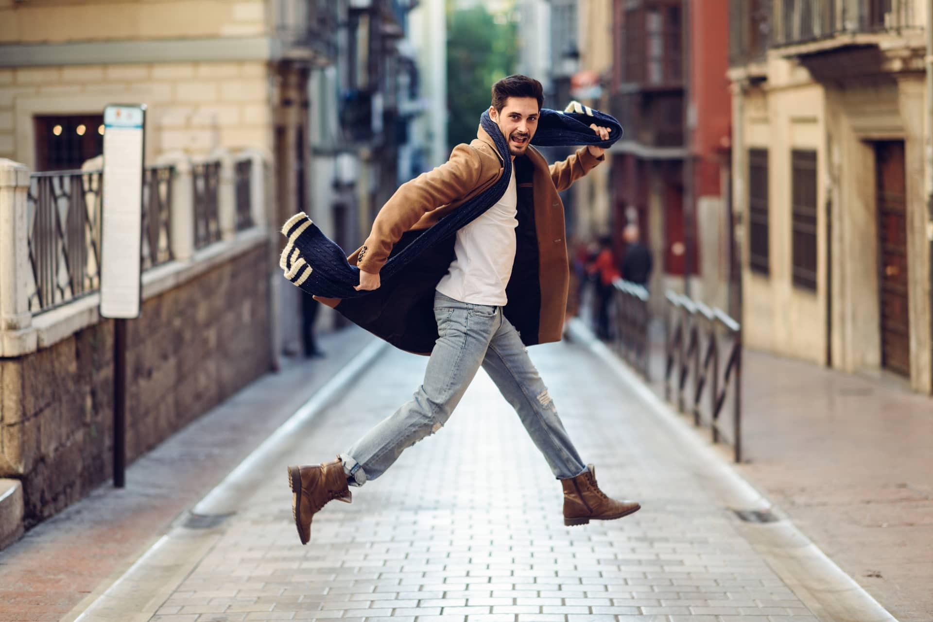 Young happy man jumping wearing winter clothes urban male pictures for fake profile