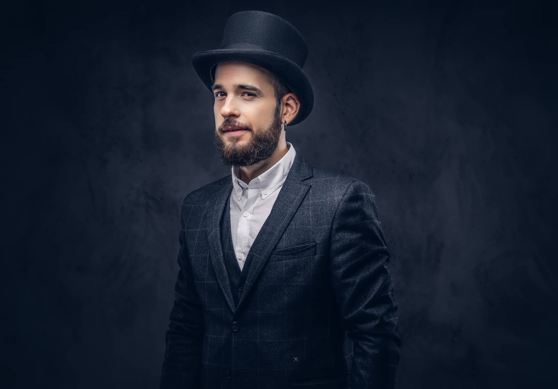 Portrait stylish bearded male elegant suit cylinder hat dark background