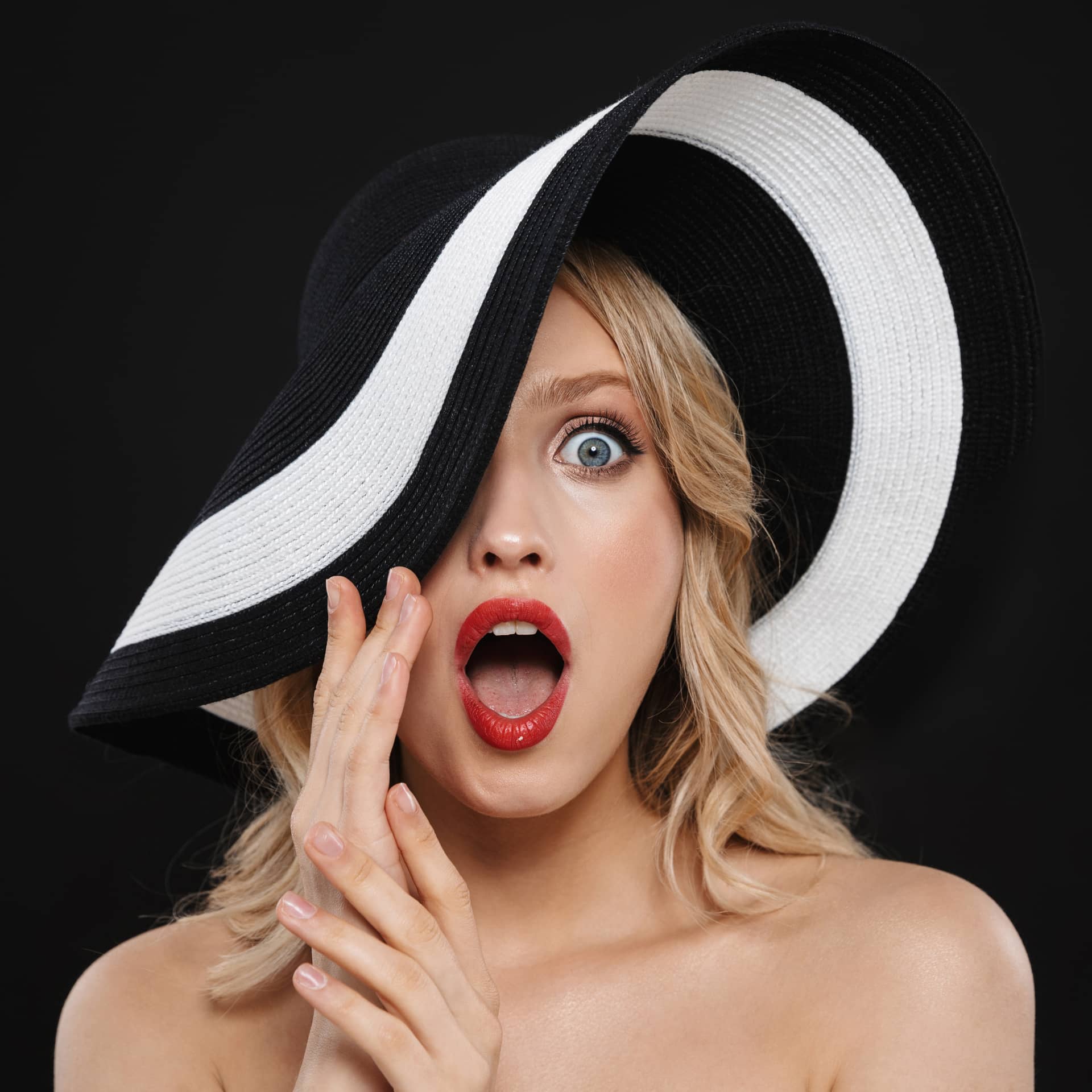 Woman with bright makeup red lips posing isolated wearing hat