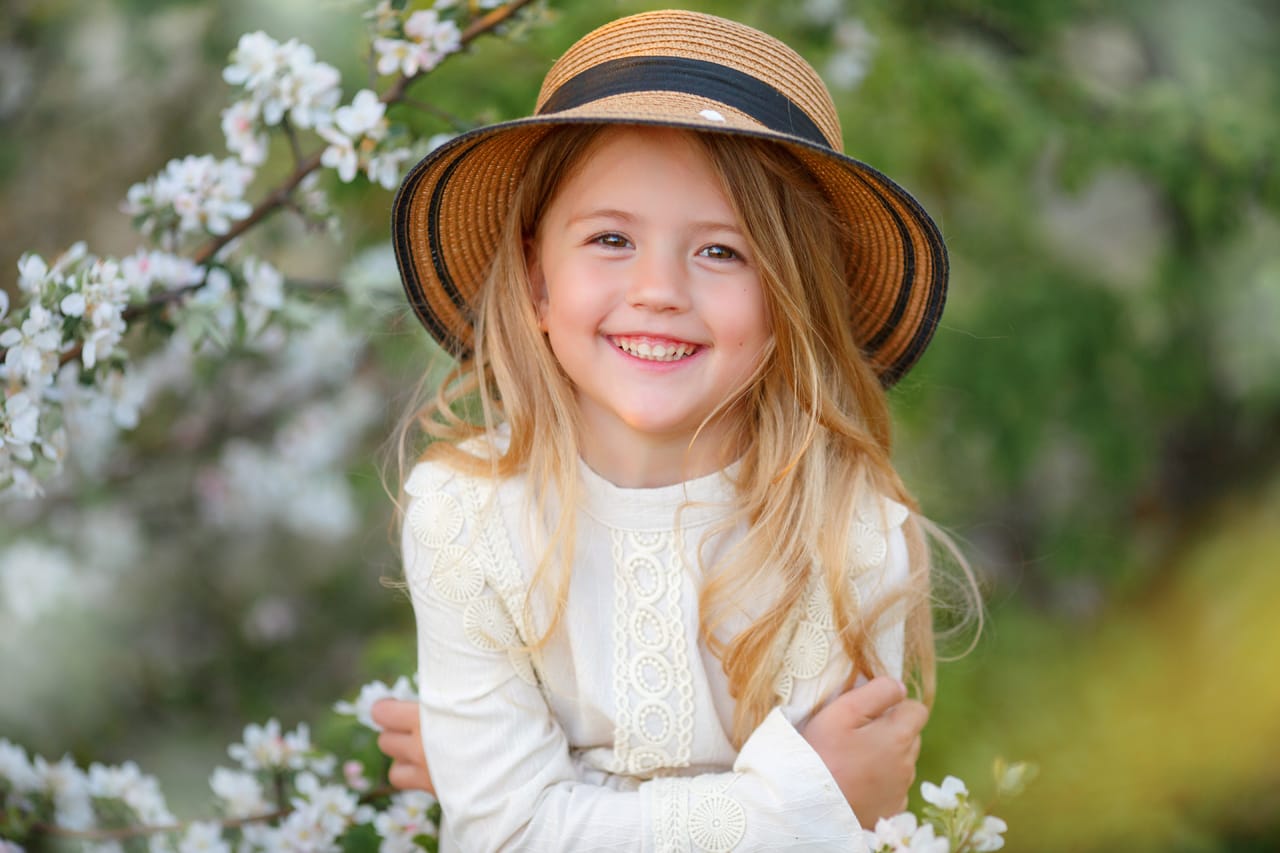 Related image little blonde girl straw hat near flowering tree