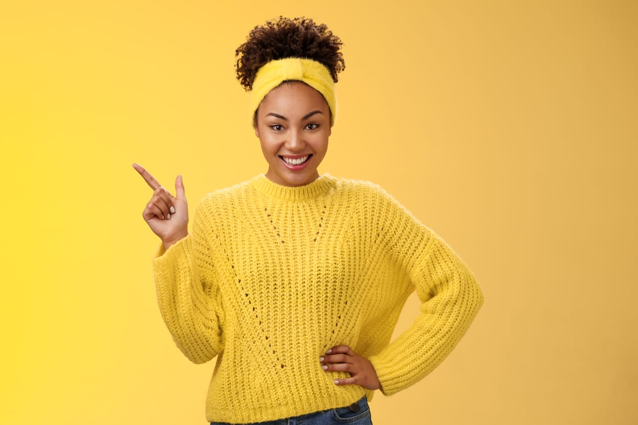 Related image charming sassy stylish african american girl sweater pointing upper left corner standing confident