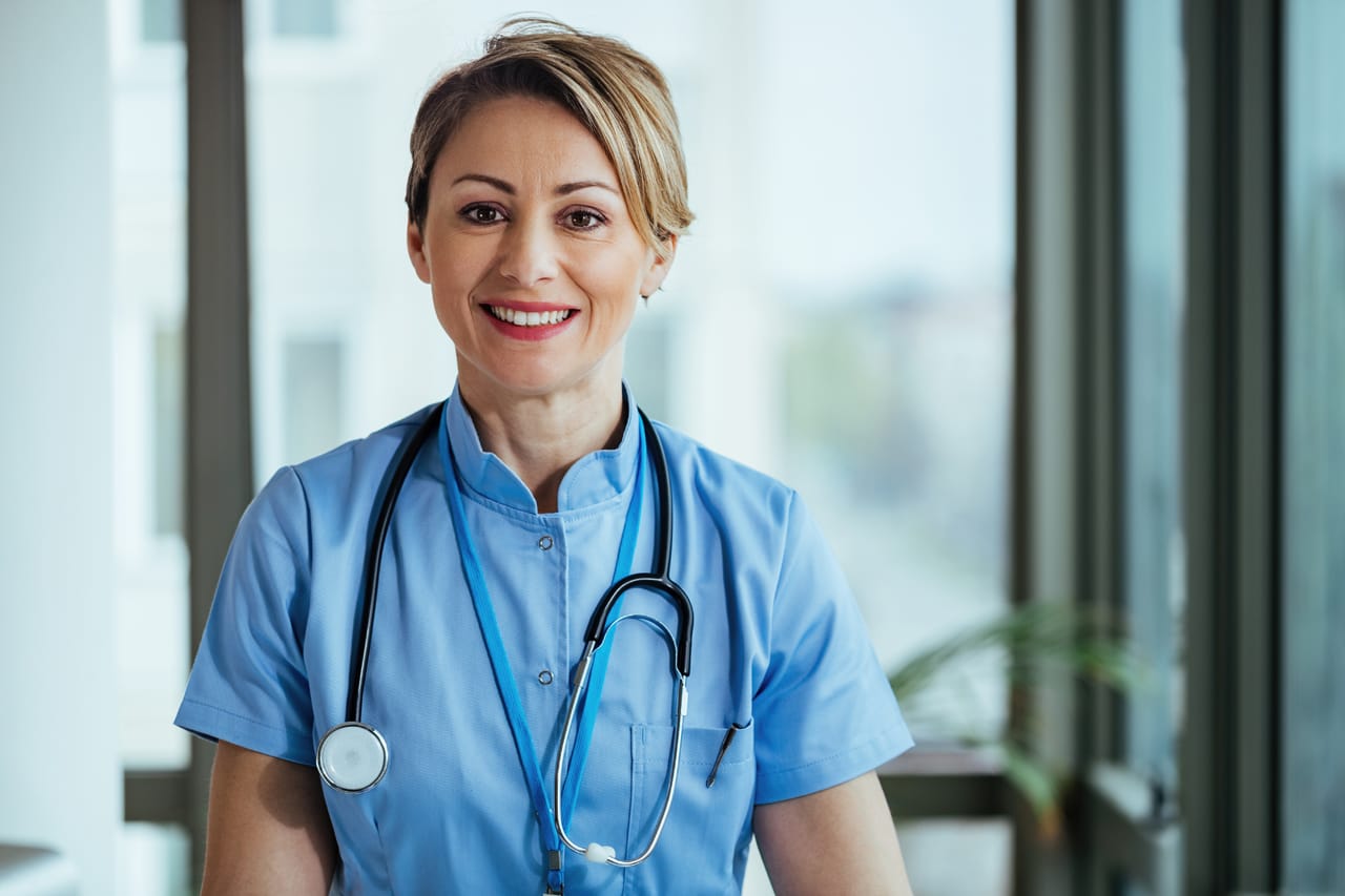Related image portrait smiling nurse looking camera while standing clinic