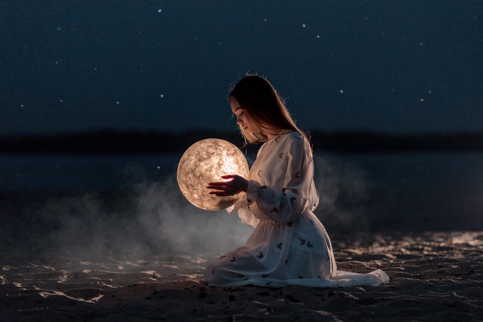 Girl night beach with sand stars holds moon her hands