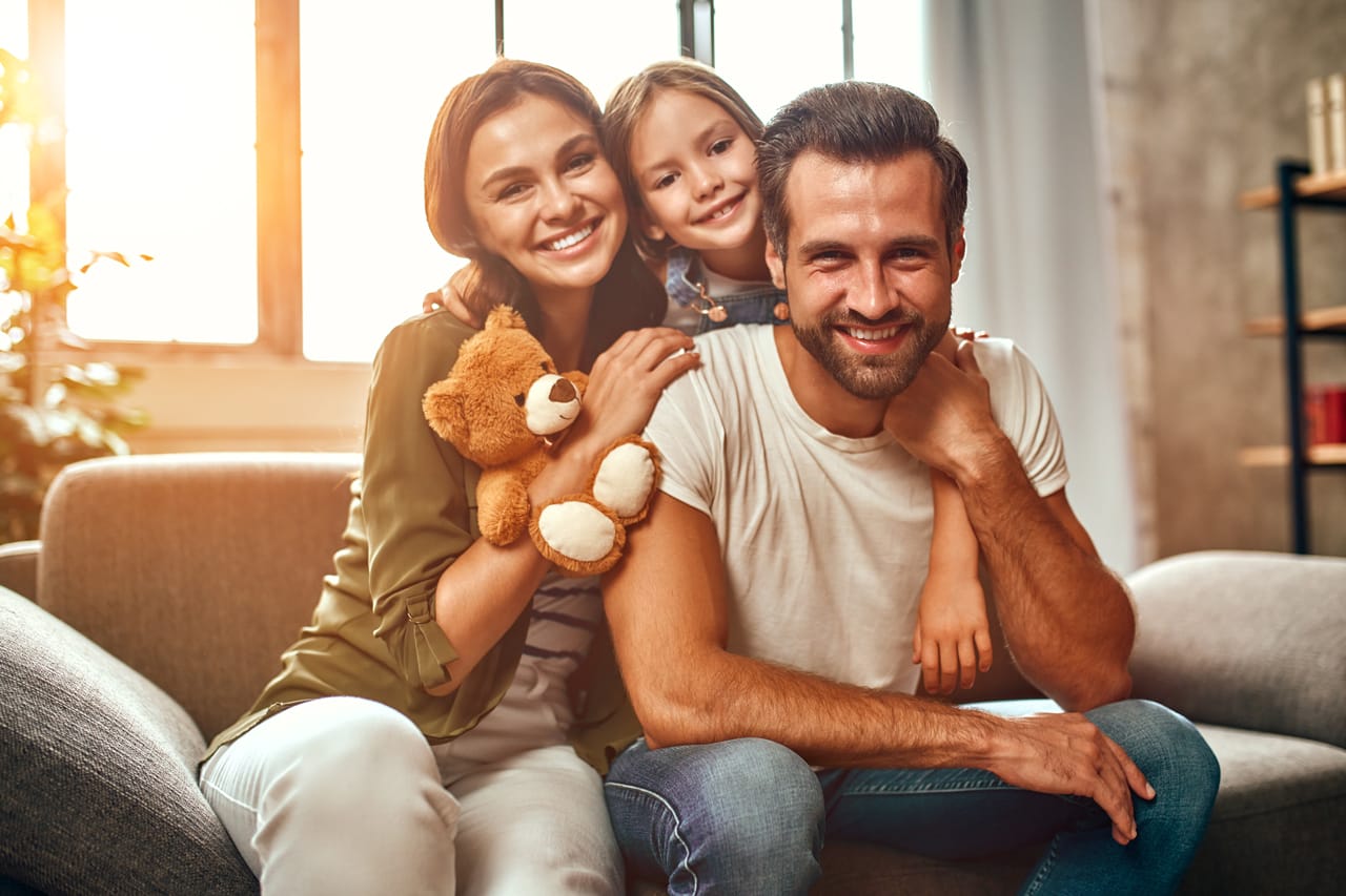 Related image happy dad mom with their cute daughter teddy bear hug have fun sitting sofa living room home