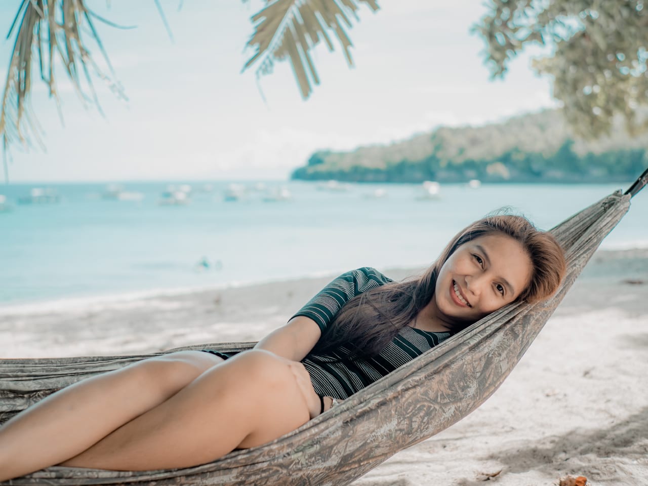 Related image a young filipinof girl is resting in a hammock by the sea